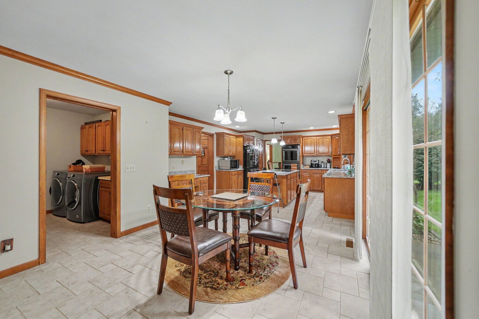 Eat-in kitchen with dining table, granite island, and wood cabinets